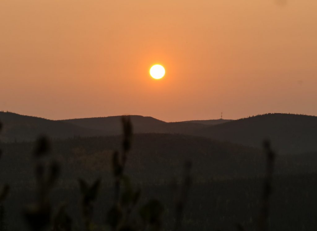 Soleil couchant orangé sur montagnes