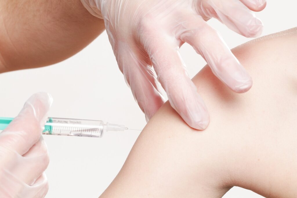 un bras qui s'apprête à recevoir un vaccin