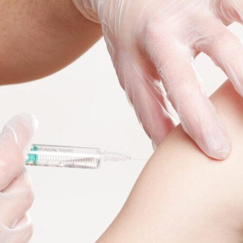 un bras qui s'apprête à recevoir un vaccin
