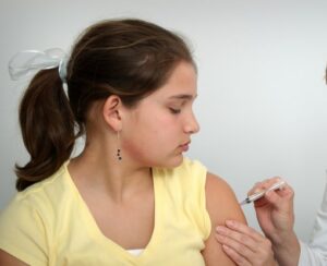 Une femme vaccine une jeune fille